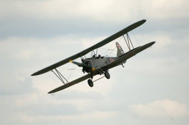 Mavi gökyüzünün arka planında eski model bir uçak.