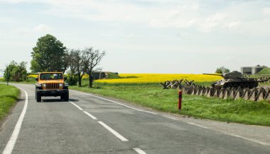 Taşra yolunda sarı bayraklı bir traktör