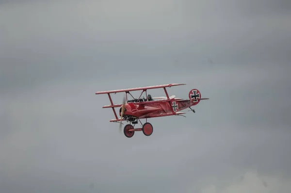 老式的红色飞机在多云的天空中飞行 — 图库照片