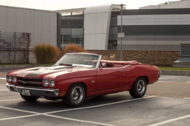 Yolun yakınına park edilmiş kırmızı araba.