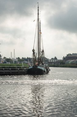 Hollanda 'daki nehirde yelkenli bir tekne.