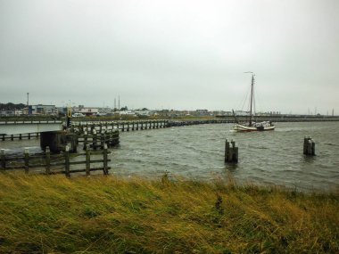 Köprüsü olan küçük ahşap bir ev ve önünde bir nehir.