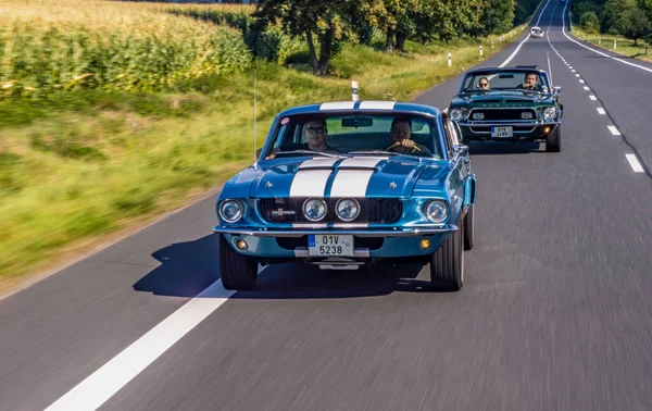 Mavi ve beyaz renkli araba yolda