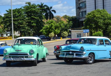 Arabalar klasik bir arabanın önüne park edilmiş.