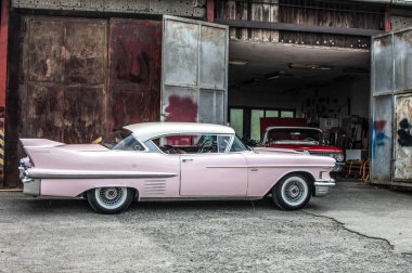 Otoparka park edilmiş terk edilmiş bir arabanın dikey görüntüsü.