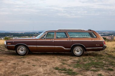 Arazinin ortasına park edilmiş eski model bir araba..