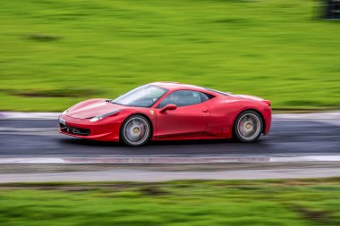 Kırmızı araba yolda.