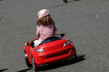 Şehirde oyuncak scooter kullanan bir çocuk.