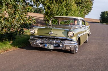 Eski model klasik araba ormanda yolda.