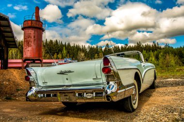 Yola park edilmiş klasik kırmızı bir araba.