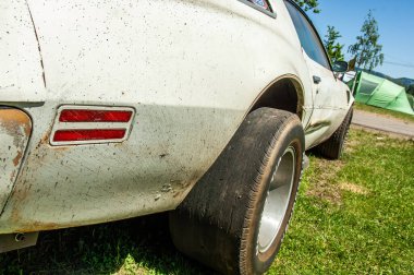 Parka park etmiş eski paslı bir araba.