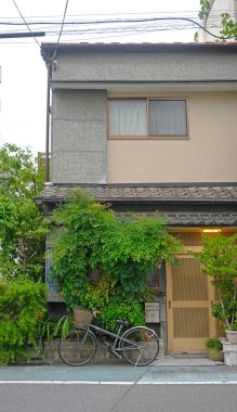 Japonya 'da gündüz vakti eski tarz bisiklet ve açık hava bitkilerine sahip dikey Japon yerleşim binası.