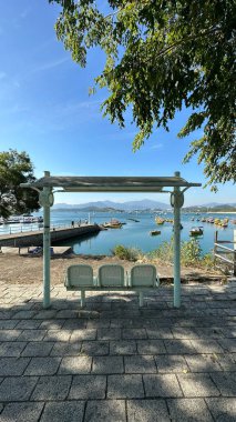 Mavi sandalyeler, patika, Hong Kong açıkhava parkı mavi gökyüzü ve gölde eğlence tekneleri.