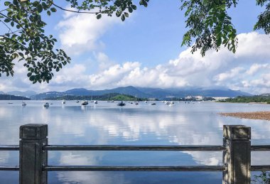 Tekneler, yelkenliler, dağ, ağaç, parktaki bulutlar.