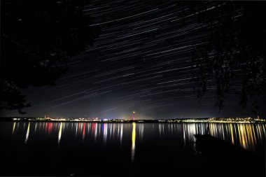 Geceleri Finlandiya 'nın Tampere kenti ve gökyüzünde yıldız izleri.