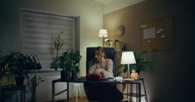 Portrait of Pensive Woman Working Late at Home Office. Contemplative Thoughtful Woman.