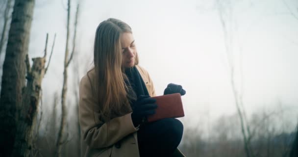 沉思沉思而苦恼的女人在公园看书的画像 — 图库视频影像