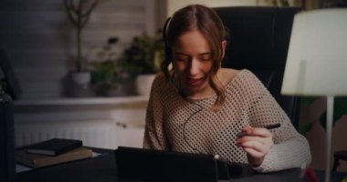 Kulaklık takmış meşgul bir iş kadını müşterisiyle konuşuyor, profesyonel bir tavır sergiliyor ve yüksek kalitede müşteri hizmetleri sağlıyor..