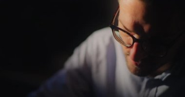 İşadamı, dizüstü bilgisayarı üzerinde çalışırken derin bir konsantrasyon ve odaklanma hissi ile düşüncelere dalmış durumda.