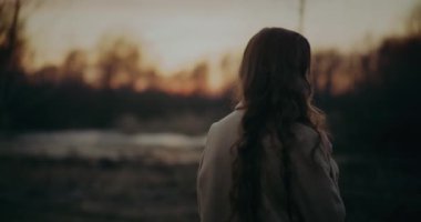 Düşünceli ve düşünceli bir kadın bir portrede yakalanmış, muhtemelen derin bir düşünce ya da tefekkür içinde. Doğal ortamın ortasında, kadın derin düşüncelere dalmış gibi görünüyor..