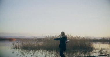 Huzurlu gölün kıyısında, doğanın güzellikleriyle çevrili dalgın bir kadın. Derin düşüncelere dalmış..