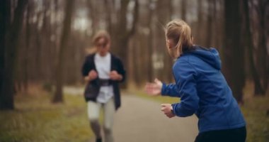 Parkta koşan ve egzersiz yapan kadınlar sağlık ve sağlık açısından harika bir gösteridir.. 
