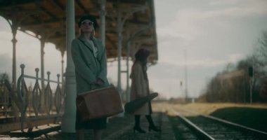 Düşünceli kadın tren istasyonunda yürüyor, treni bekliyor..