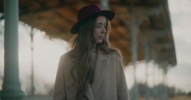 Tren istasyonundaki düşünceli ve düşünceli kadın kendi düşüncelerinde kaybolmuş, derin düşüncelere dalmış ve yansımasına dalmış.