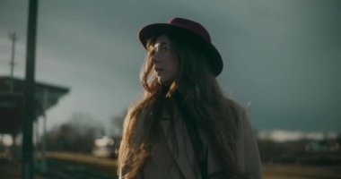 Tren istasyonundaki düşünceli ve düşünceli kadın kendi düşüncelerinde kaybolmuş, derin düşüncelere dalmış ve yansımasına dalmış.