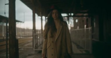 Tren istasyonundaki düşünceli ve düşünceli kadın kendi düşüncelerinde kaybolmuş, derin düşüncelere dalmış ve yansımasına dalmış.