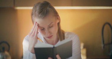 İş kadını, yüzünde dalgın bir ifadeyle derin düşüncelere daldı. Düşünüyor ve düşünüyor gibi görünüyor.