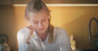 İş kadını, yüzünde dalgın bir ifadeyle derin düşüncelere daldı. Düşünüyor ve düşünüyor gibi görünüyor.