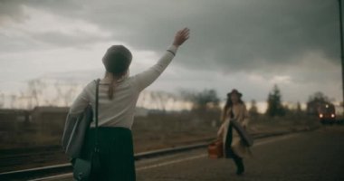 İki arkadaş tren istasyonundan ayrılan trene yetişmek için acele ediyor.