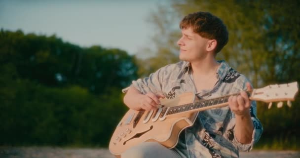积极快乐的人在夏日黄昏时弹奏吉他 和谐与无忧无虑的意念 — 图库视频影像