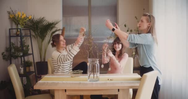 イースター休暇のためのテーブルを飾る姉妹 イースターエッグとイースターデコレーション — ストック動画
