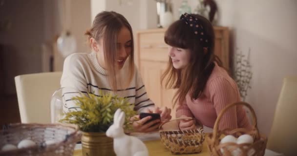 イースターの朝食の間 姉妹はデジタル接続に従事し スマートフォンやソーシャルメディアを閲覧して更新され 接続されます ソーシャルメディアへの依存 — ストック動画