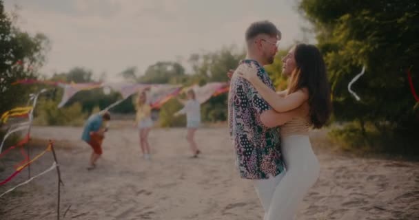 若い男性と女性のスローモーションショットビーチでギターで夏の週末パーティーを楽しみながらバカータを踊る — ストック動画