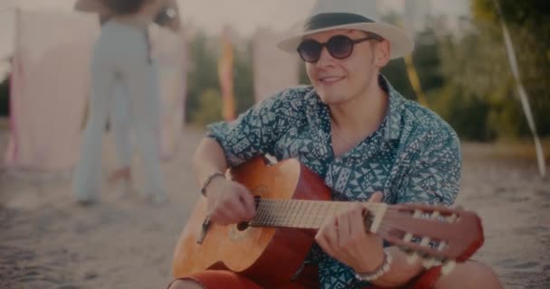 젊은이가 어쿠스틱 기타를 연주하는 해변에서 부부가바 카타를 — 비디오