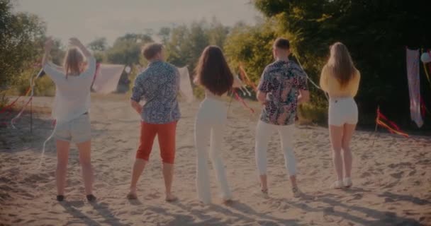 週末はビーチサイドに立ちながら踊る若い男女の友達の全長リアビュー — ストック動画