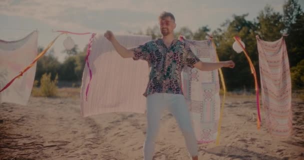 Улыбающийся Молодой Человек Танцующий Музыку Сражаясь Саронгами Висящими Пляже Солнечный — стоковое видео