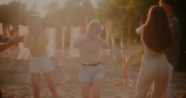 Boldog Szőke Táncol Körül Barátok Tapsolnak Éljenzik Strandon Naplementekor — Stock videók