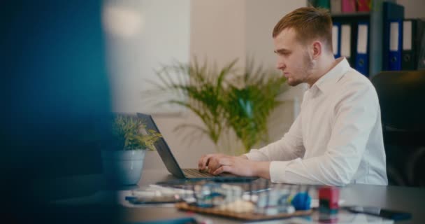 Ciddi Genç Adamlarının Ofiste Dizüstü Bilgisayar Kullanması Yavaş Bir Hareket — Stok video
