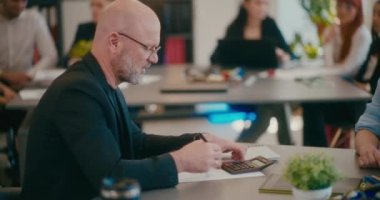 Olgun erkek yönetici iş stratejisini ofisteki meslektaşına açıklıyor..