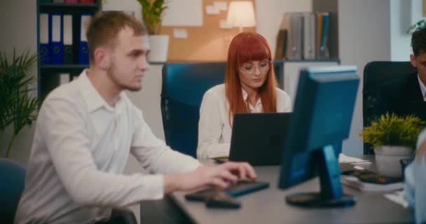 办公室里的同事们用笔记本电脑让红头发的年轻女商人慢动作 — 图库视频影像