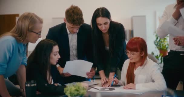 オフィスでの会議中に文書を介してチームと議論する女性マネージャーのスローモーション — ストック動画