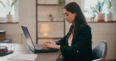 Ofiste dizüstü bilgisayarla çalışan konsantre genç bir iş kadınının yavaş hareketi..