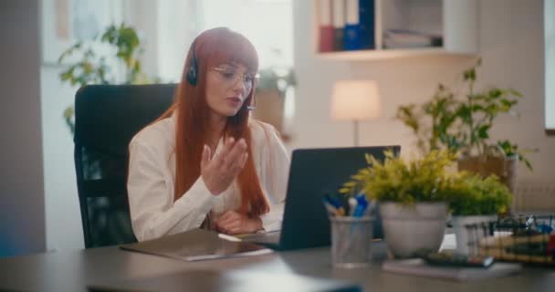 Redhead Kvinnlig Kund Representant Bär Headset Arbetar Laptop Vid Skrivbordet — Stockvideo