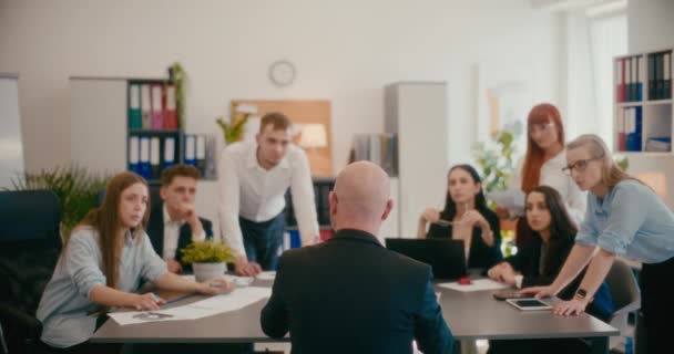 オフィスでの会議中にチームにビジネス戦略を説明する男性マネージャーのスローモーション — ストック動画