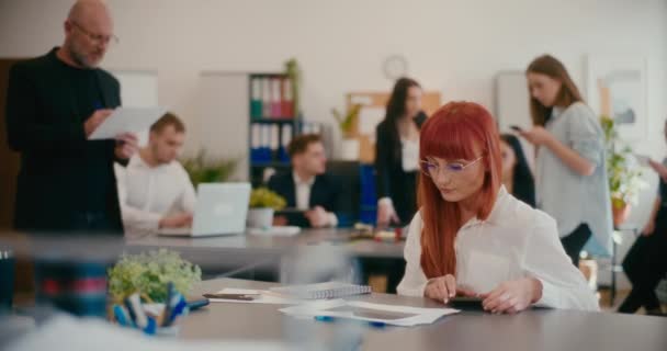 红头发紧张的员工在办公室里检查文件的慢动作 — 图库视频影像