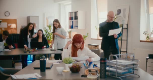オフィスのデスクで文書を分析する赤毛の実業家のスローモーション — ストック動画